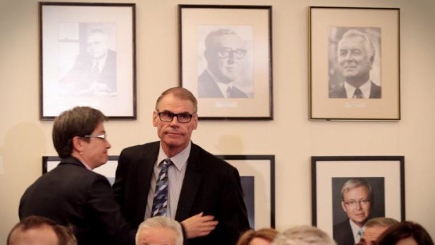Senator John Faulkner is embraced by Senator Penny Wong beneath a portrait of former Prime Minister Gough Whitlam in the caucus room at Parliament House.