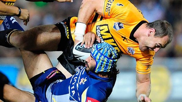 Johnathan Thurston of the Cowboys is tackled by Gareth Ellis of the Tigers.
