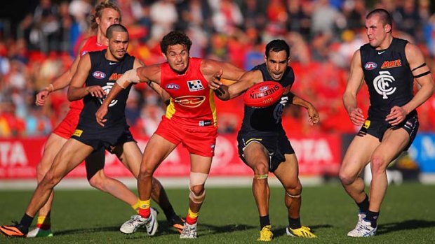 Gold Coast's Jarrod Harbrow and Carlton's Eddie Betts compete for the ball.