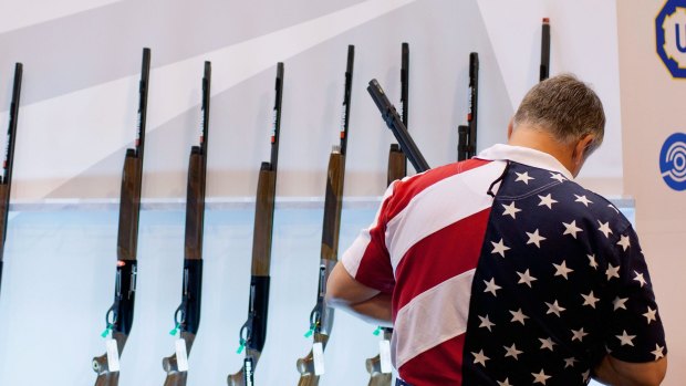 A man inspects shotguns at a gun expo in St Louis, Missouri.