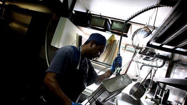 Unsung heroes scour dirty dishes in the kitchen