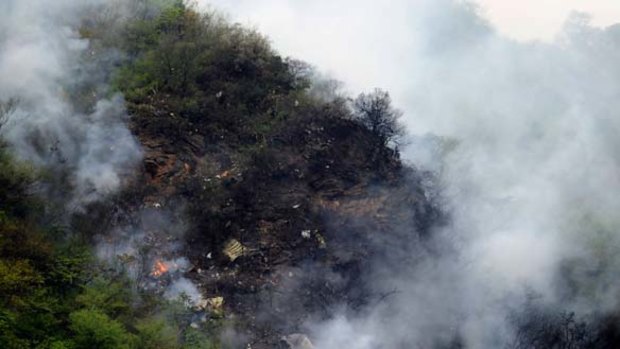 Fire and smoke rise from the wreckage of a passenger plane crashed at The Margalla Hills on the outskirts of Islamabad.
