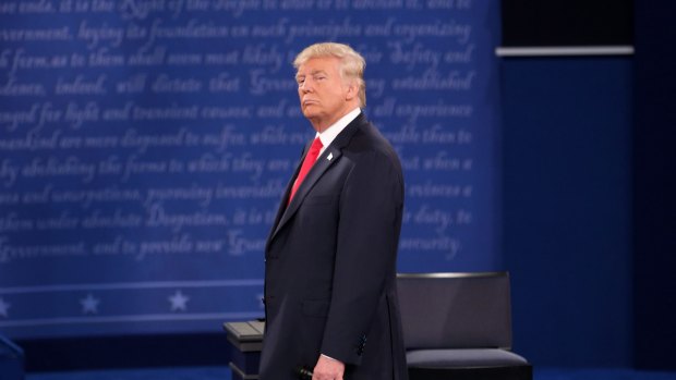 Donald Trump, 2016 Republican presidential nominee, stands during the second U.S. presidential debate at Washington University in St. Louis, Missouri, U.S., on Sunday, Oct. 9, 2016. As has become tradition, the second debate will resemble a town hall meeting, with the candidates free to sit or roam the stage instead of standing behind podiums, while members of the audience -- uncommitted voters, screened by the Gallup Organization -- will ask half the questions. Photographer: Daniel Acker/Bloomberg