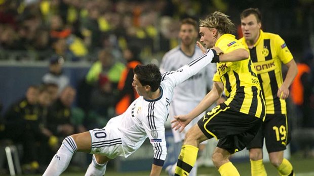 Dortmund defender Marcel Schmelzer (second right) and Real Madrid midfielder Mesut Ozil vie for the ball.