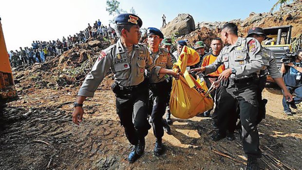 Indonesian police carry a victim during an evacuation at Cikangkareng village in Cibinong.