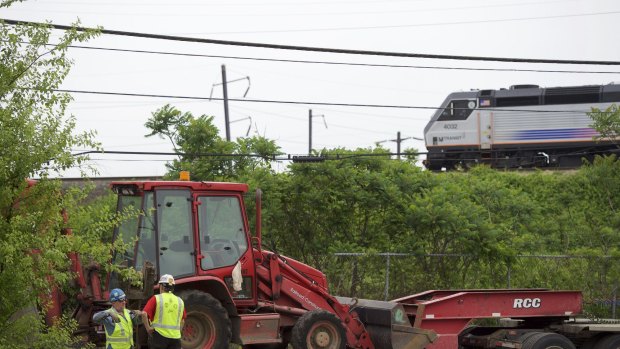 Construction workers haul in heavy machinery to repair damaged train tracks at the crash site of this week's Amtrak passenger train on May 15, 2015 in Philadelphia.