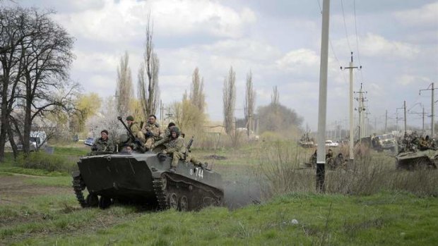 Ukrainian servicemen drive armoured personnel carriers into Kramatorsk.
