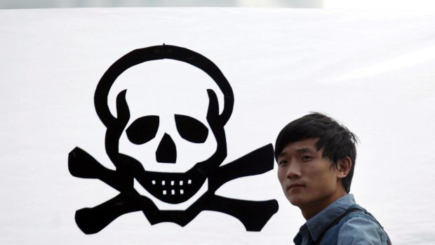 Sometimes civil action reaps dividends. A protester stands in front of a banner in 2012 to protest against plans to expand a petrochemical plant in Zhejiang province. The expansion was suspended.