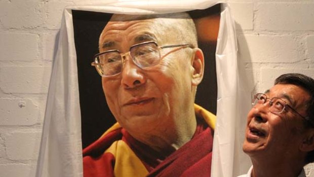 "Gun for hire" ... Tenzin Choegyal, next to a picture of his older brother, the Dalai Lama.