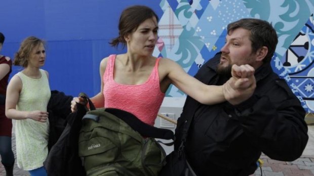 A Russian security officer arrests Tolokonnikova. Alikhina is on her left.
