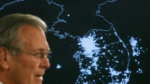 Blackout ... The then US Secretary of Defence, Donald Rumsfeld, speaks in front of a satellite image of the Korean peninsula at night, showing the lights of South Korea and the relative darkness of the North, 2006.