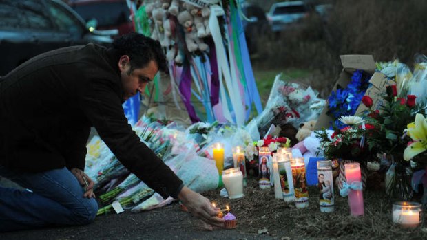 A man pays tribute to the victims of an elementary school shooting in Newtown, Connecticut on Saturday.