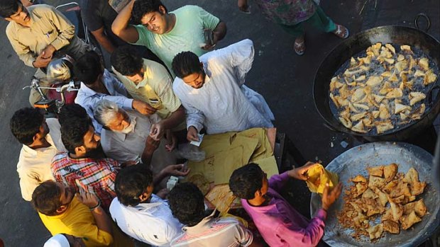 Soul food... Lahore workers buy samosas to break the first day of fasting during Ramadan.