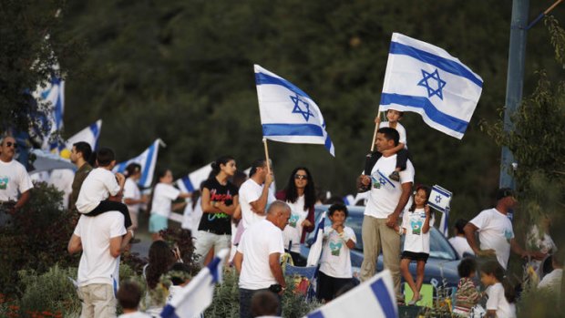 Supporters of freed soldier Gilad Shalit wave Israeli flags to celebrate his release.
