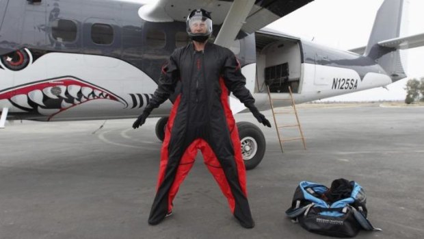 Daredevil jumper Joby Ogwyn shows reporters his prototype wing-suit.