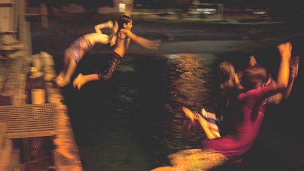 Moments of peace &#8230; kids leap off the jetty into Flying Fish Cove, often a scene of drama - and sometimes tragedy - as asylum seekers finally reach Christmas Island. Photos: James Brickwood