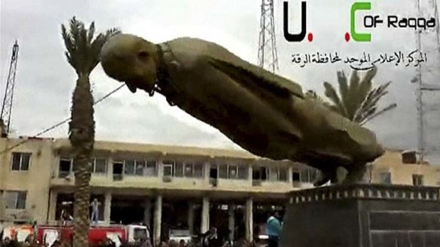 A statue of President Bashar Al-Assad's father, Hafez Al-Assad, is torn down after Syrian opposition fighters captured the northeastern city of Raqqa.
