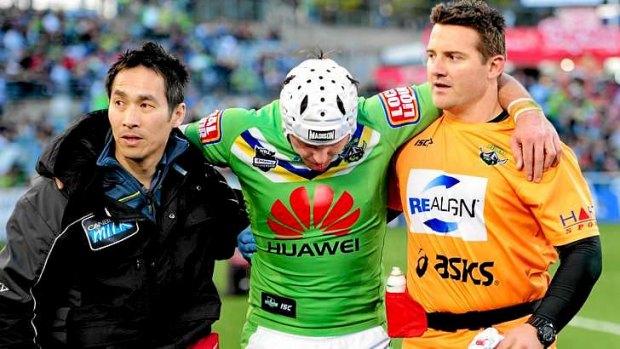 Wilson Lo and Leigh Woodbridge assist Jarrod Croker from the field during the 2012 finals.