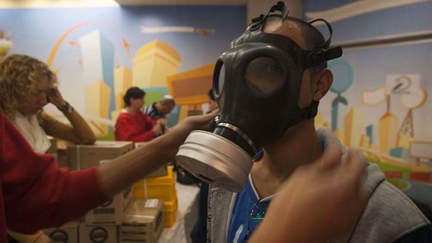Tension in the air &#8230; an Israeli tries on a gas mask in East Jerusalem. Syria has accused Israel of Wednesday's air strike, increasing the likelihood of retaliation.