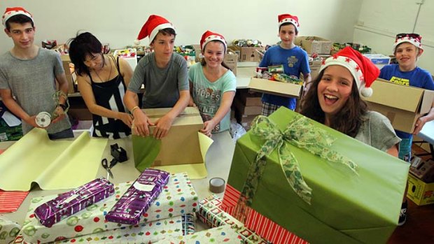 Sweet charity: Giselle Laszok (far right), who has been volunteering with Kids Giving Back, with a Christmas hamper.