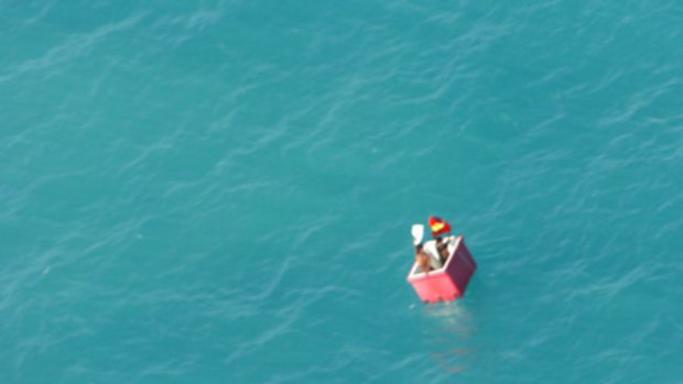 The lost fishermen wave from their 'flotation device' - an icebox - in the Torres Strait.