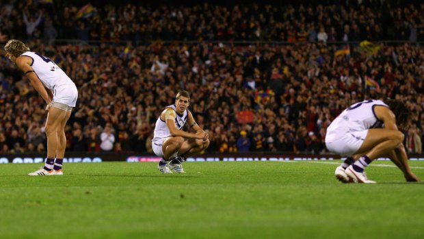 Dockers down: Fremantle players slump, dejected after their loss to Adelaide at AAMI Stadium.