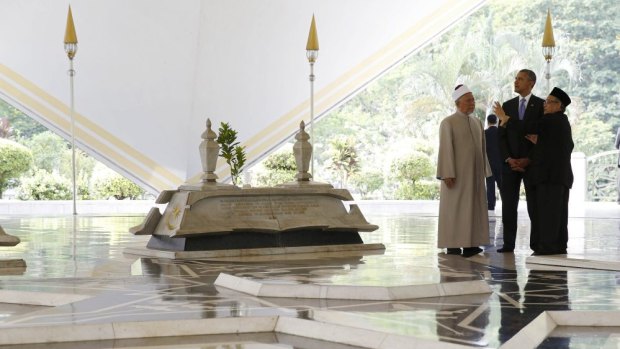 In Kuala Lumpur, US President Barack Obama receives a tour from the Grand Imam Tan Sri Syaikh Ismail Muhammad and Abdul Rashid Bin Md Isa  right while he visits the Warrior Mausoleum at the National Mosque of Malaysia.