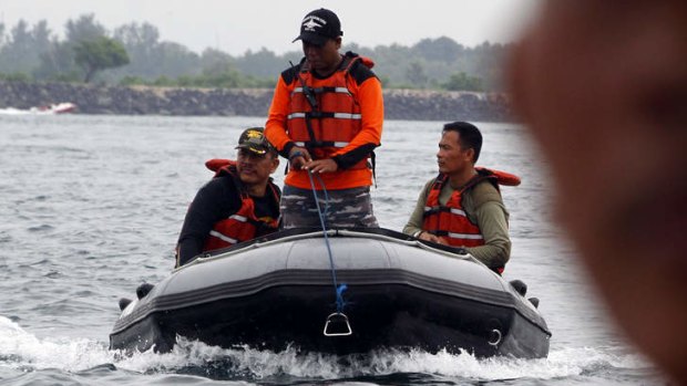Indonesian navy rescue team members return to shore after searching for the seven Japanese divers.