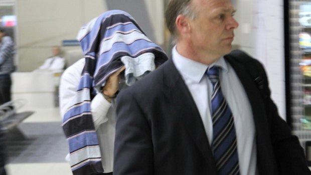 Charged ... Paul Darren Mulvihill led away by police in Brisbane yesterday.