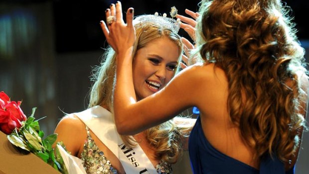 Miss Universe Australia 2011, Scherri-Lee Biggs, is presented with her winner's tiara by last year's winner, Jesinta Campbell.