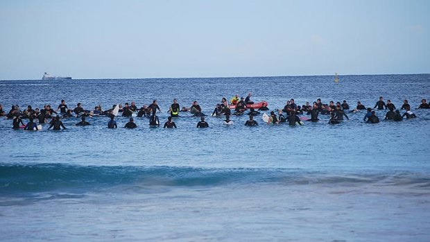 Surfers arrange themselves in a circle at Brighton Beach, to honour the memory of Ben Linden, who was killed in a shark attack at Wedge Point a fortnight ago.