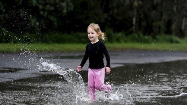A girl runs through a puddle in the Sydney suburb of Penrith.