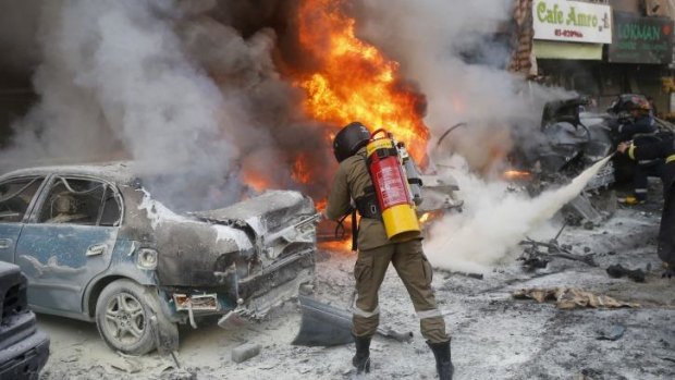 Lebanese firefighters extinguish fire from burning cars following an explosion in Beirut.