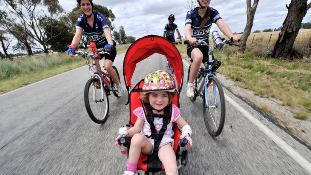 Four-year-old Madeline Norman sits back and enjoys the ride as dad Andrew pumps the pedals.