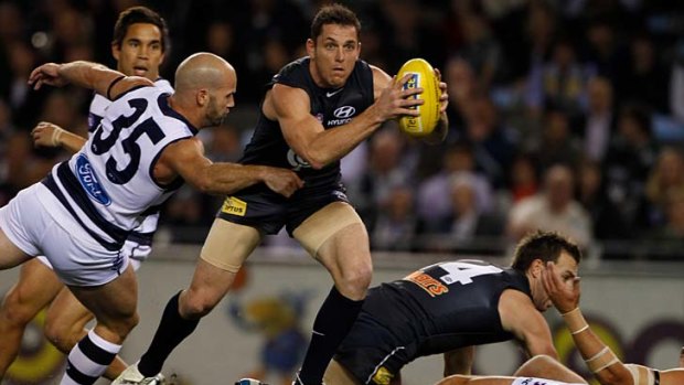 At a stretch: Geelong's Paul Chapman arrives too late to tackle Blues midfielder Heath Scotland.