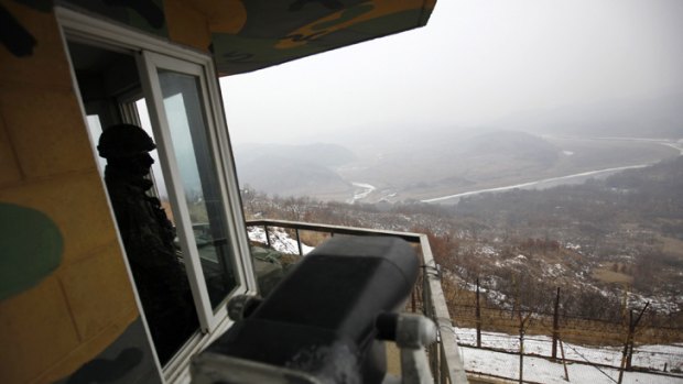 A waiting game ... a South Korean soldier looks over the DMZ to North Korea.