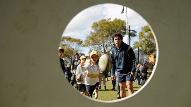 Matt Toomua gives some tips to children at a Wallabies fan day in Circular Quay on Thursday.