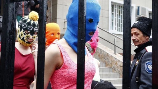 Masked members of protest band Pussy Riot leave a police station in Adler during the 2014 Sochi Winter Olympics.