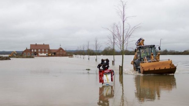A mechanical digger is driven through floodwater in Somerset, south-west England.