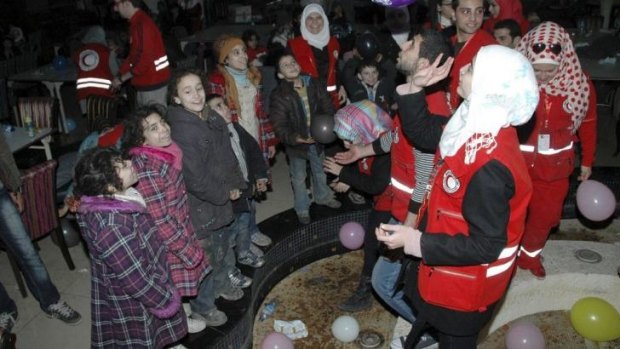 Respite: Members of the Syrian Red Crescent play with children who have fled Homs.