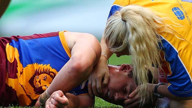 Jonathan Brown lies on the pitch after being injured during a match against Geelong last year.