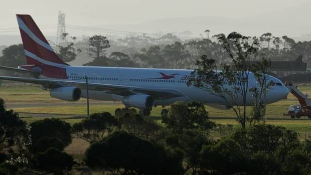 Passengers disembark from the Air Mauritius Airbus that had taxied to a remote part of Melbourne Airport after the flight had been aborted following the discovery of something 'weird'.