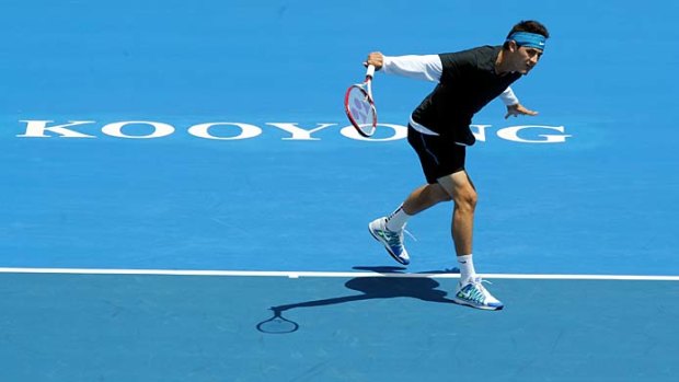 On the move: Bernard Tomic defied the strong winds and rival Tomas Berdych at Kooyong yesterday.