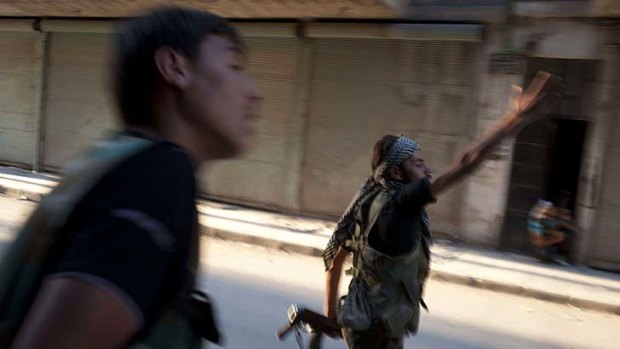 Syrian rebel fighters take fire from a helicopter in the Bustan Pasha neighborhood of Aleppo.