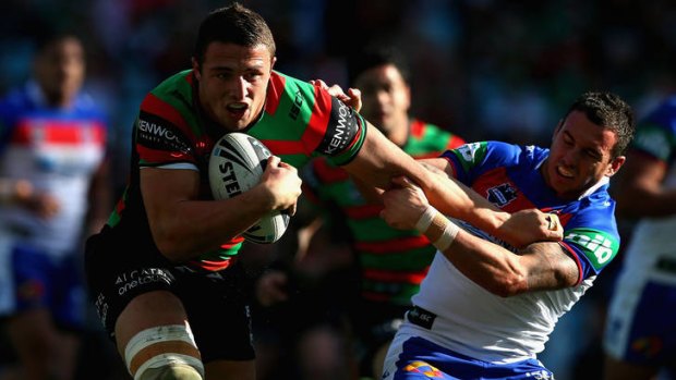 Souths forward Sam Burgess, left, is tackled by Knights hooker Danny Buderus.