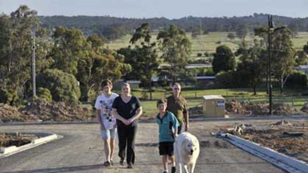 Heather and Rod Higgins with sons Dale and Leigh in the new estate opposite their house.