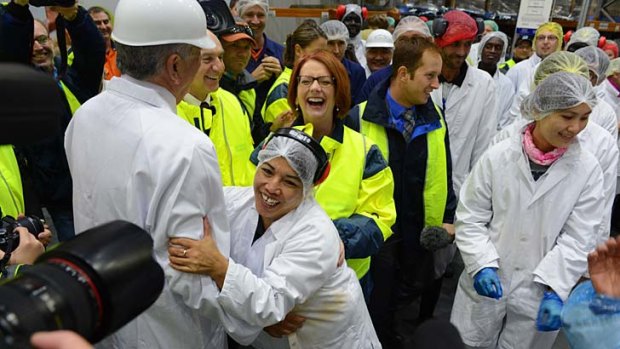 Ham act &#8230; a worker at a meat factory in Brisbane hugs a company executive during a visit by the Prime Minister, Julia Gillard, on Monday.