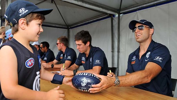 Chris Judd signs autographs for fans. The captain will be seen in action only in the second weekend of March.