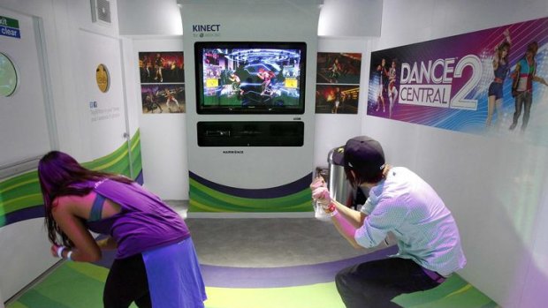 Attendees play the Dance Central 2 for the Xbox 360 Kinect.