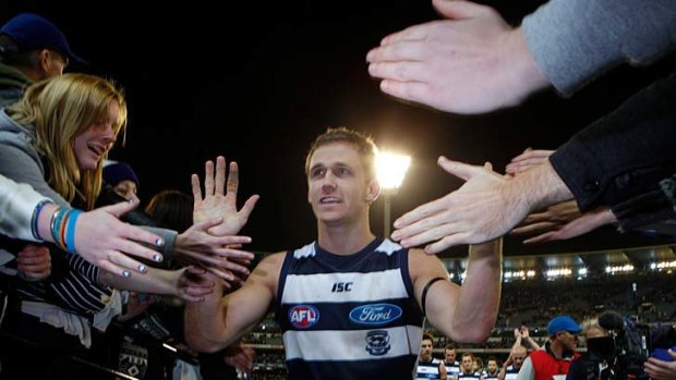Cats midfielder Joel Selwood high fives supporters after Geelong's victory in his 100th game.